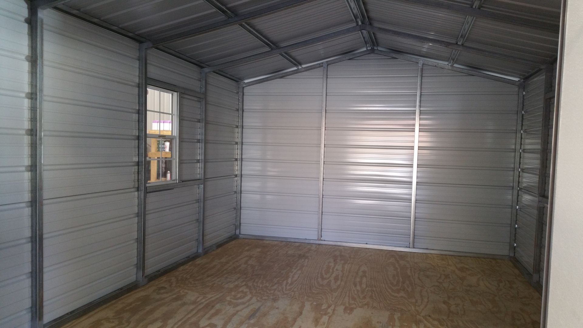 A white and gray metal building with a door and windows on a white background.