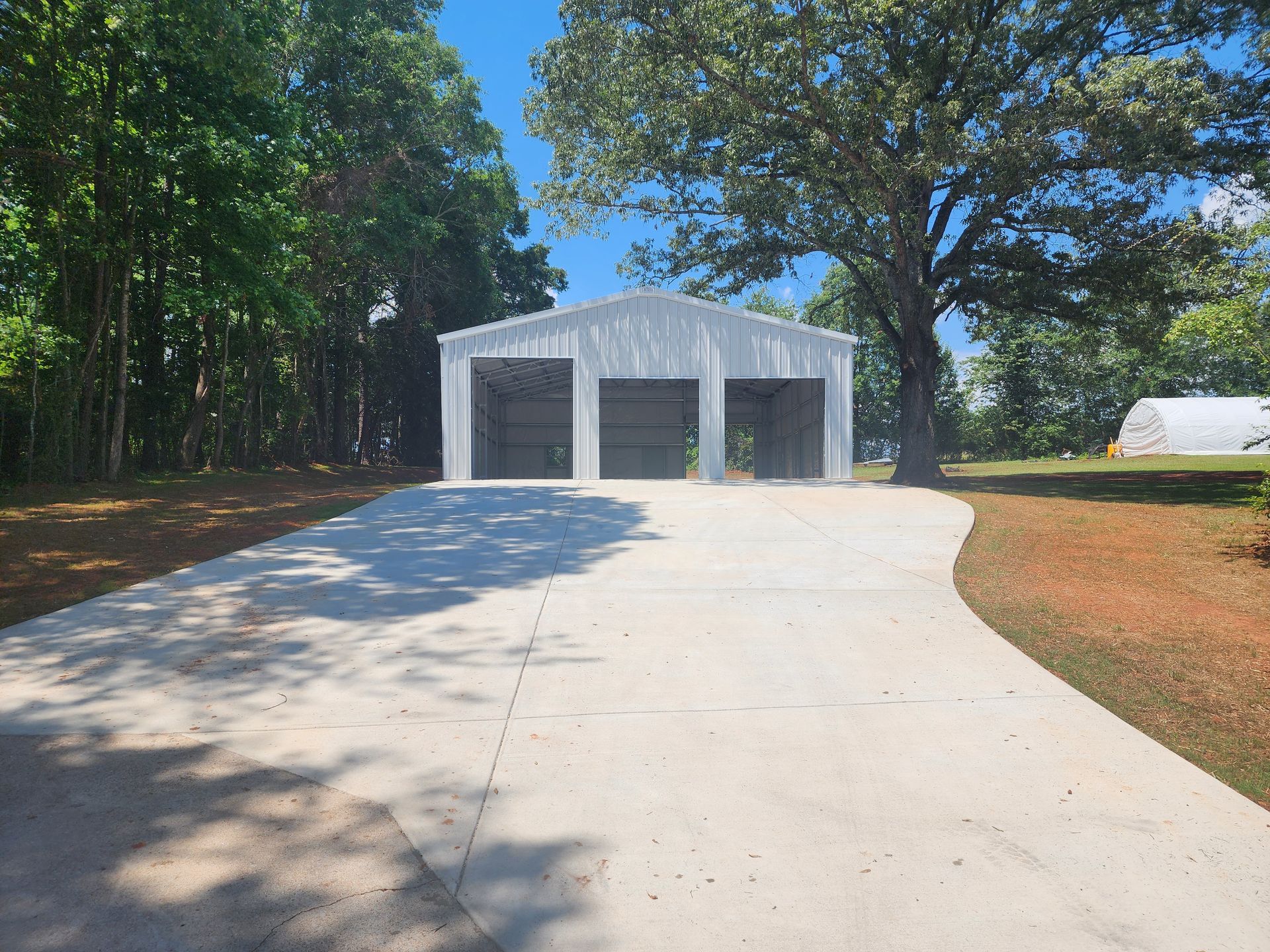 A driveway leading to a white garage with three garage doors.