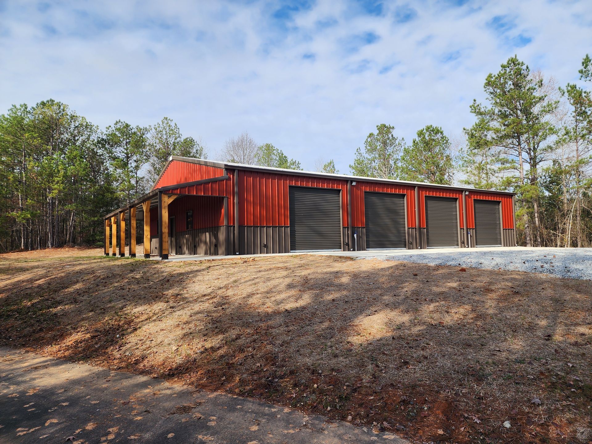 Red and gray storage units with black doors, on a hillside with trees in background.
