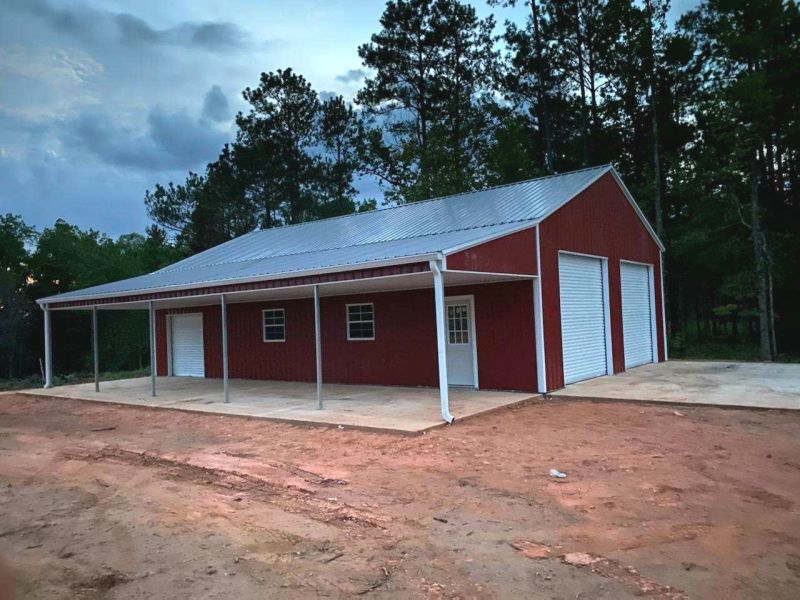 A large red barn with white doors and a porch