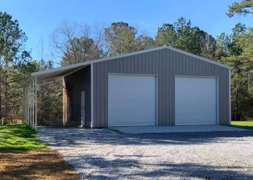 A large metal garage with two garage doors and a canopy.