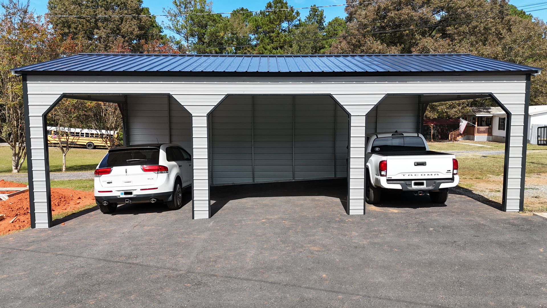 Three-bay metal carport with a white SUV and a white pickup truck parked inside.