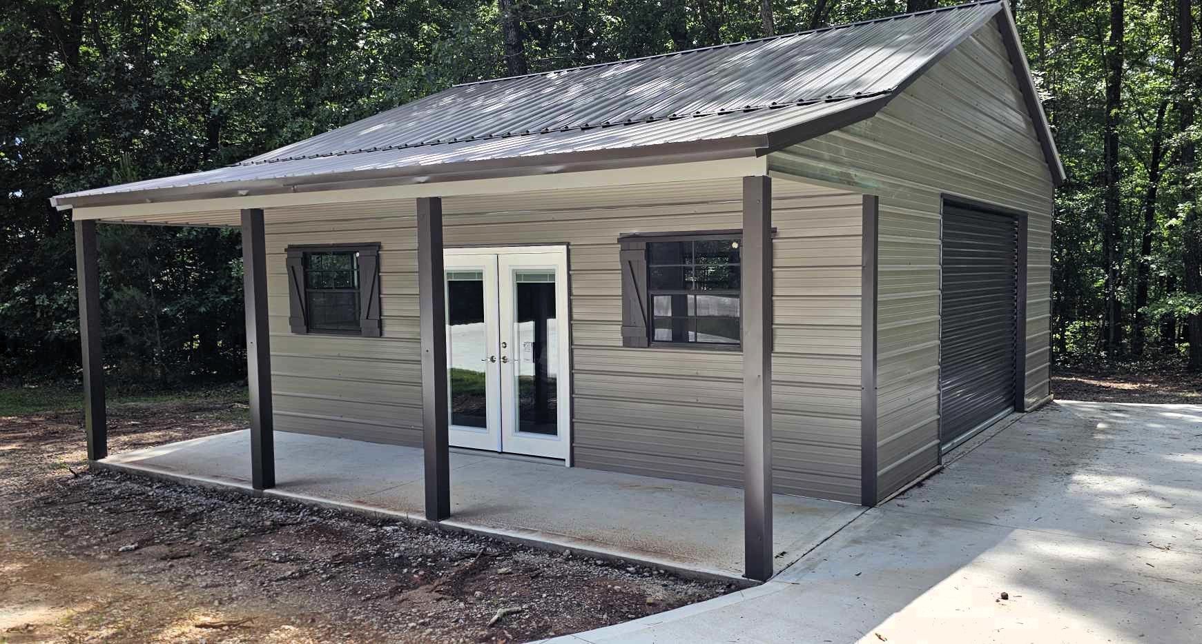 Steel building with porch, windows, double doors, and roll-up garage door, set on a concrete pad.