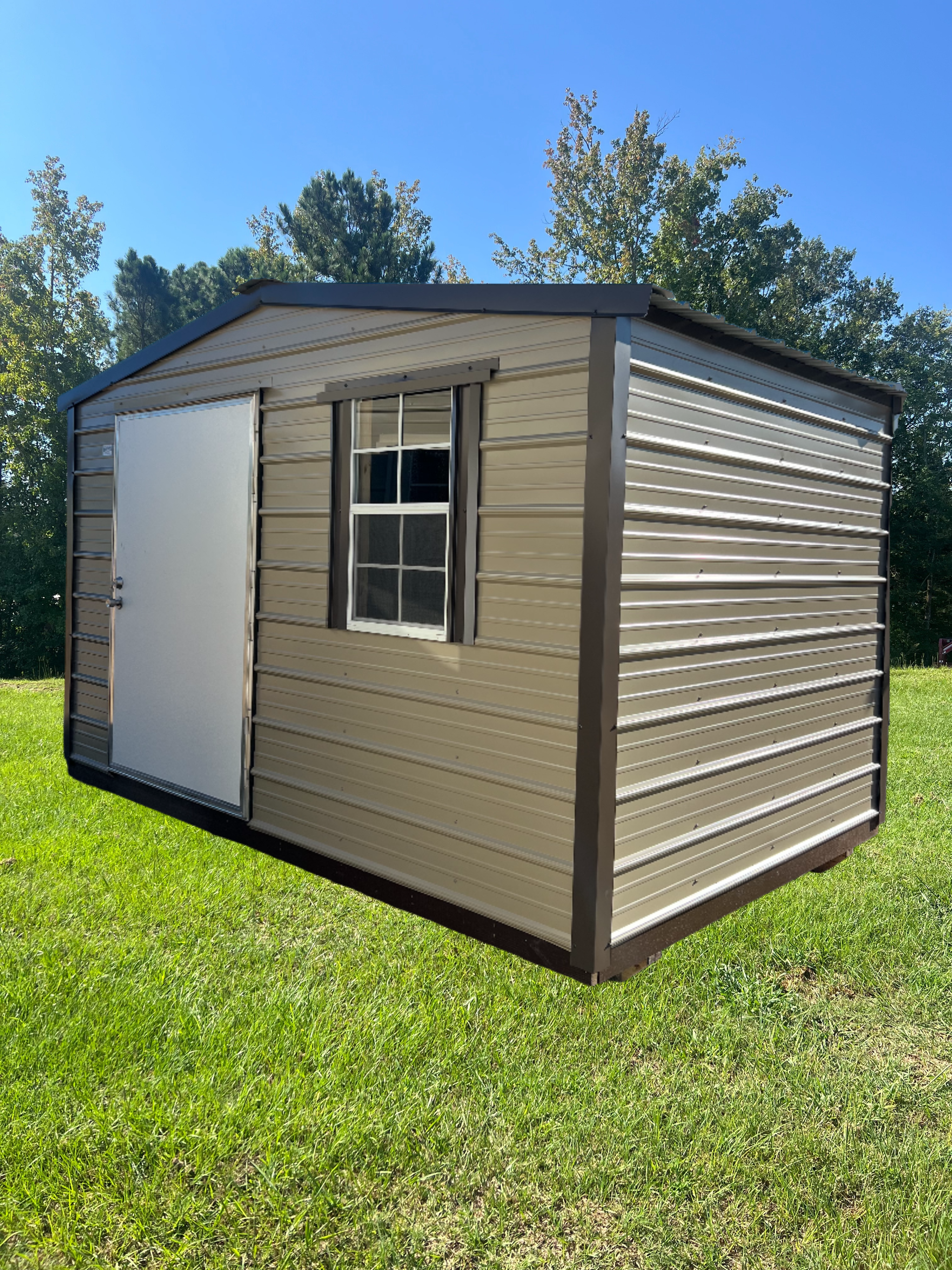 Tan and brown metal shed with a white door and small window, set on a green lawn.