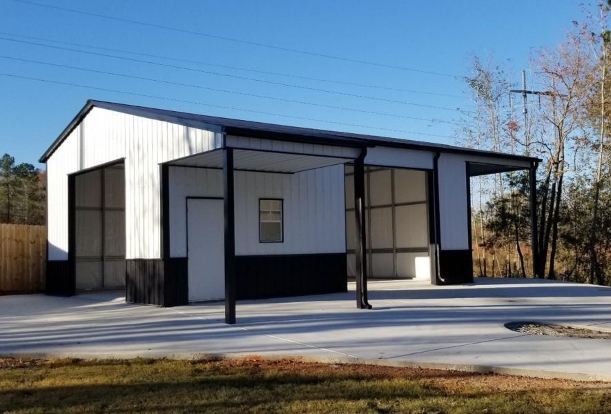 A white and black garage with a porch and a driveway.