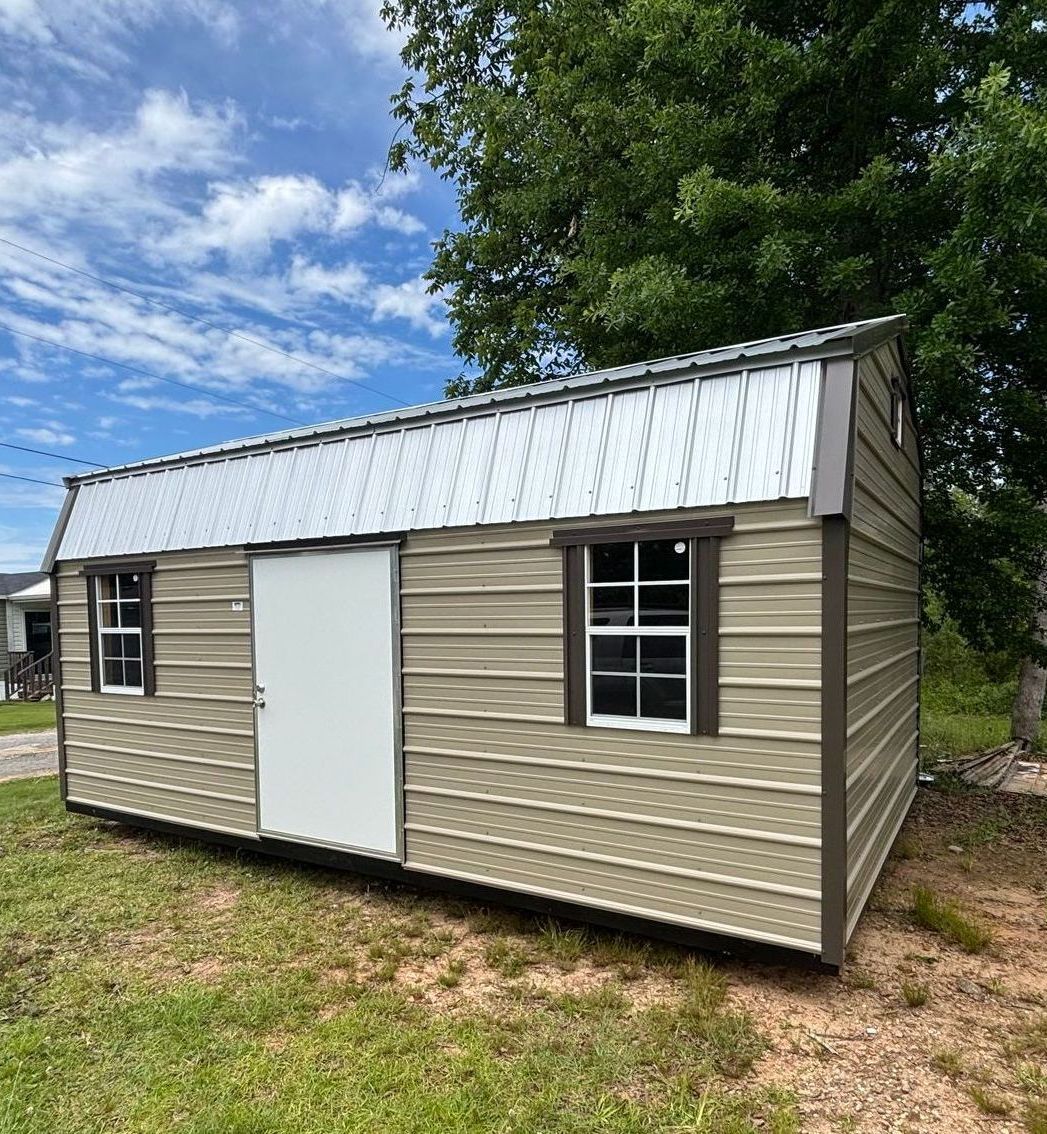 Tan shed with brown trim, white door and window, and metal roof outdoors.