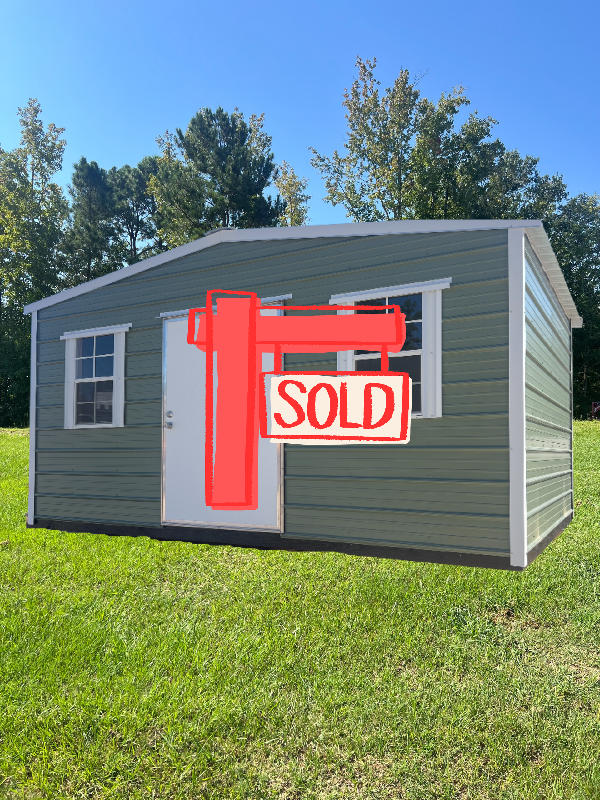 Green shed with white trim and door, two windows, set in grass.