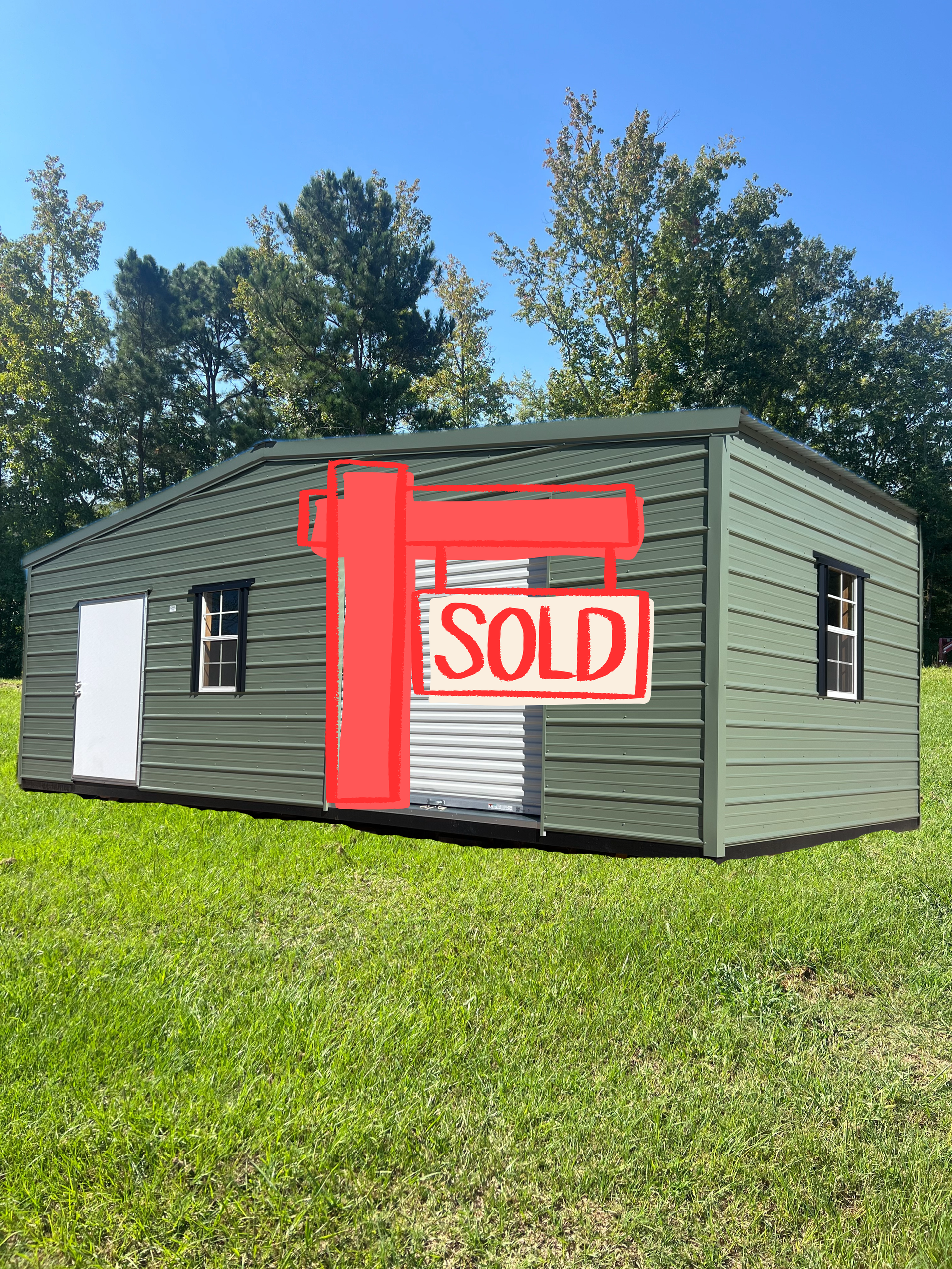 A sage green metal storage shed with a roll-up door, a single white door, and two windows, set on a grassy lawn.