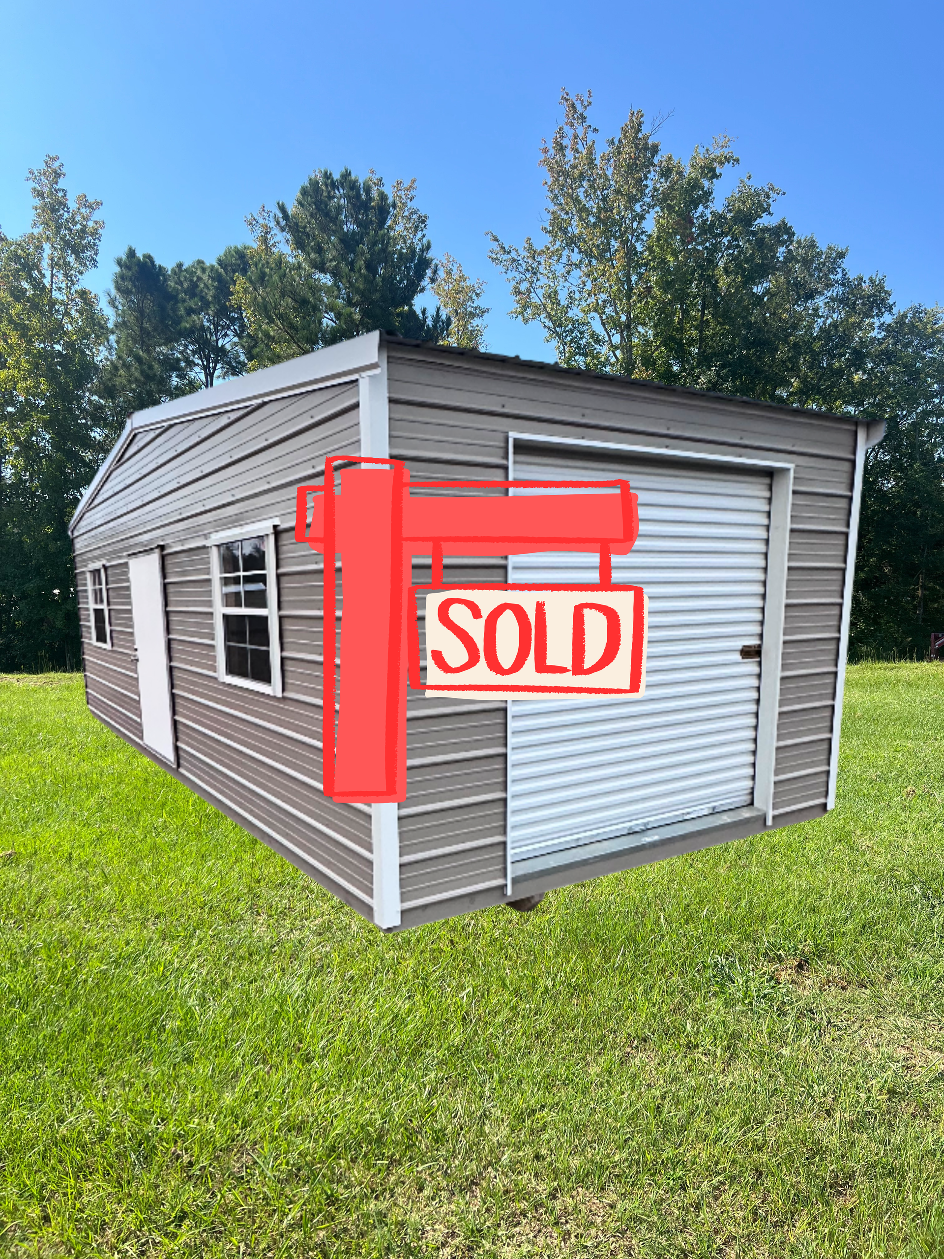 Gray shed with white trim, roll-up door, window, and door, set in a grassy yard.