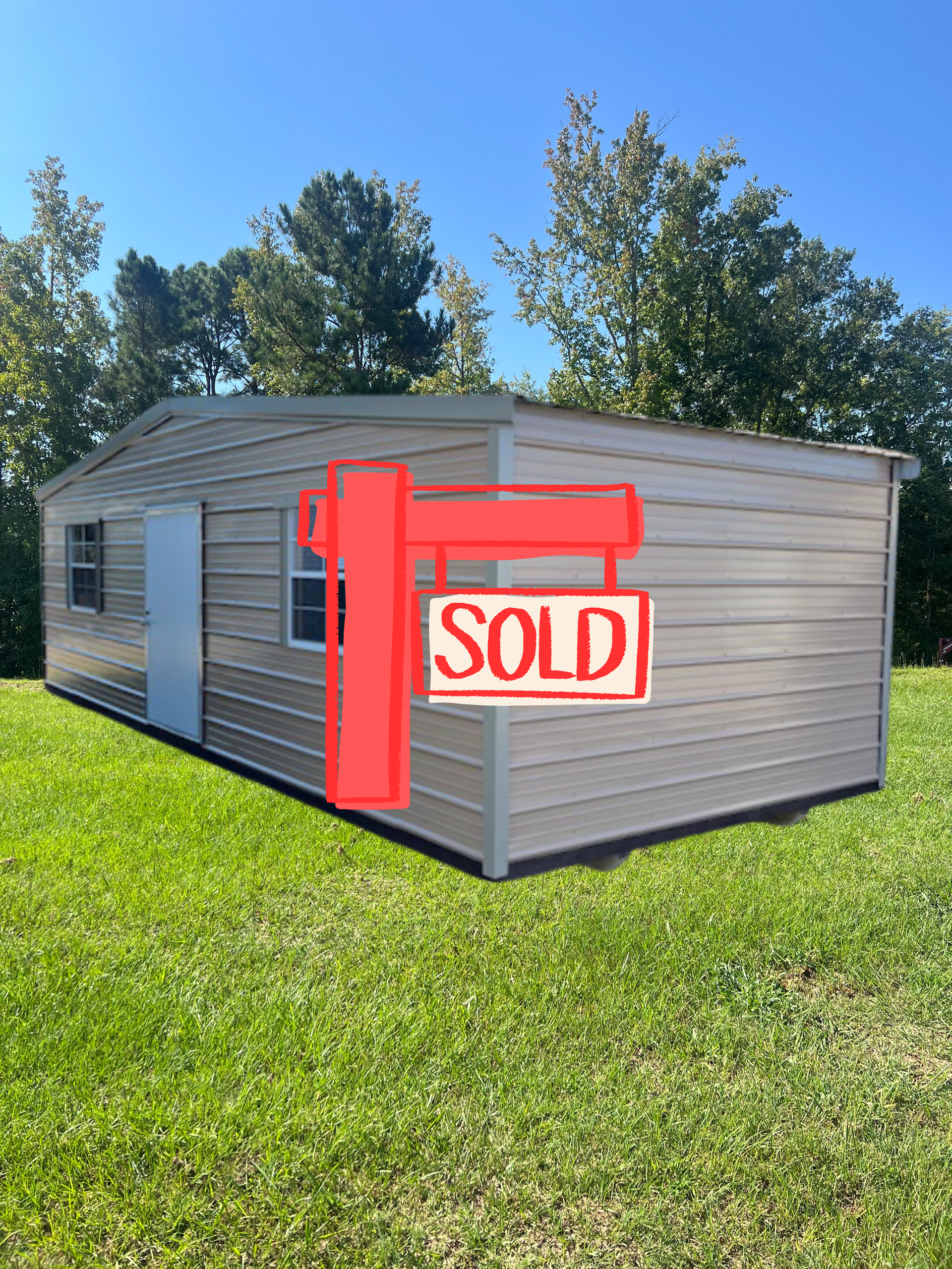Small gray shed on a grassy lot with a red 