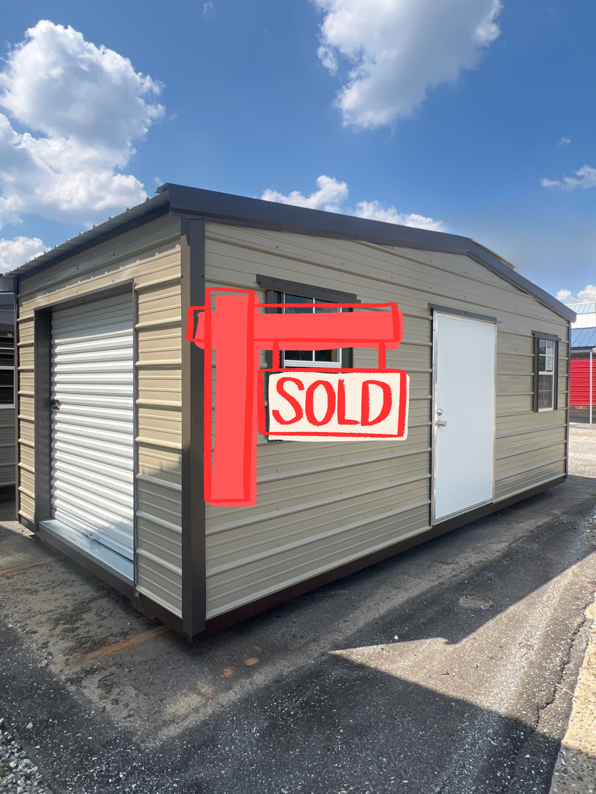 Tan metal shed with brown trim; roll-up door, window, and door; blue sky background.