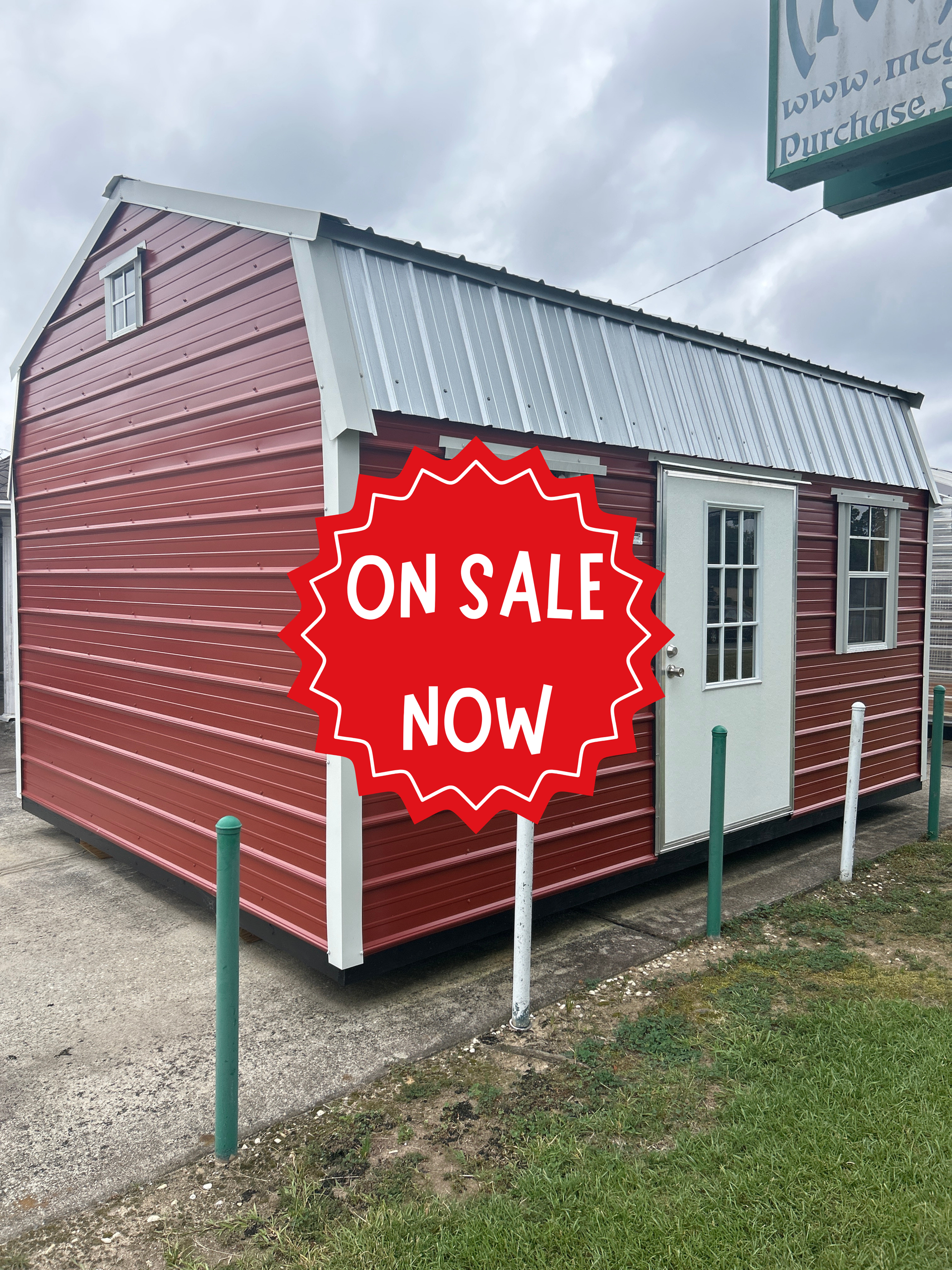 Red and white tiny house on gravel lot with a bright red “On Sale Now” sign
