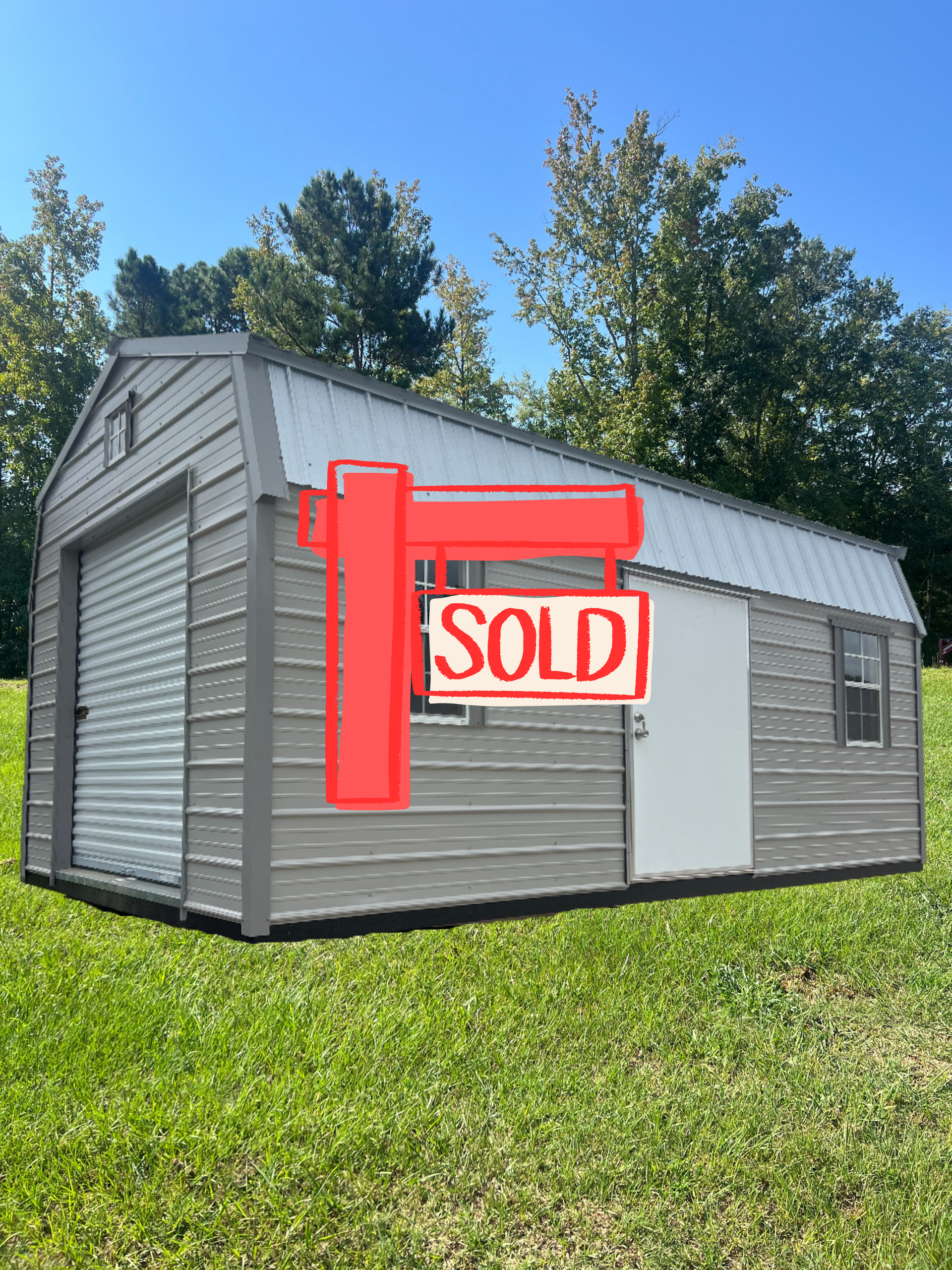 Tan and brown barn-style shed with silver roof, white door, and windows on gravel.