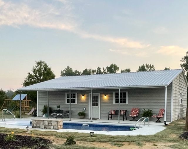 A house with a swimming pool in front of it