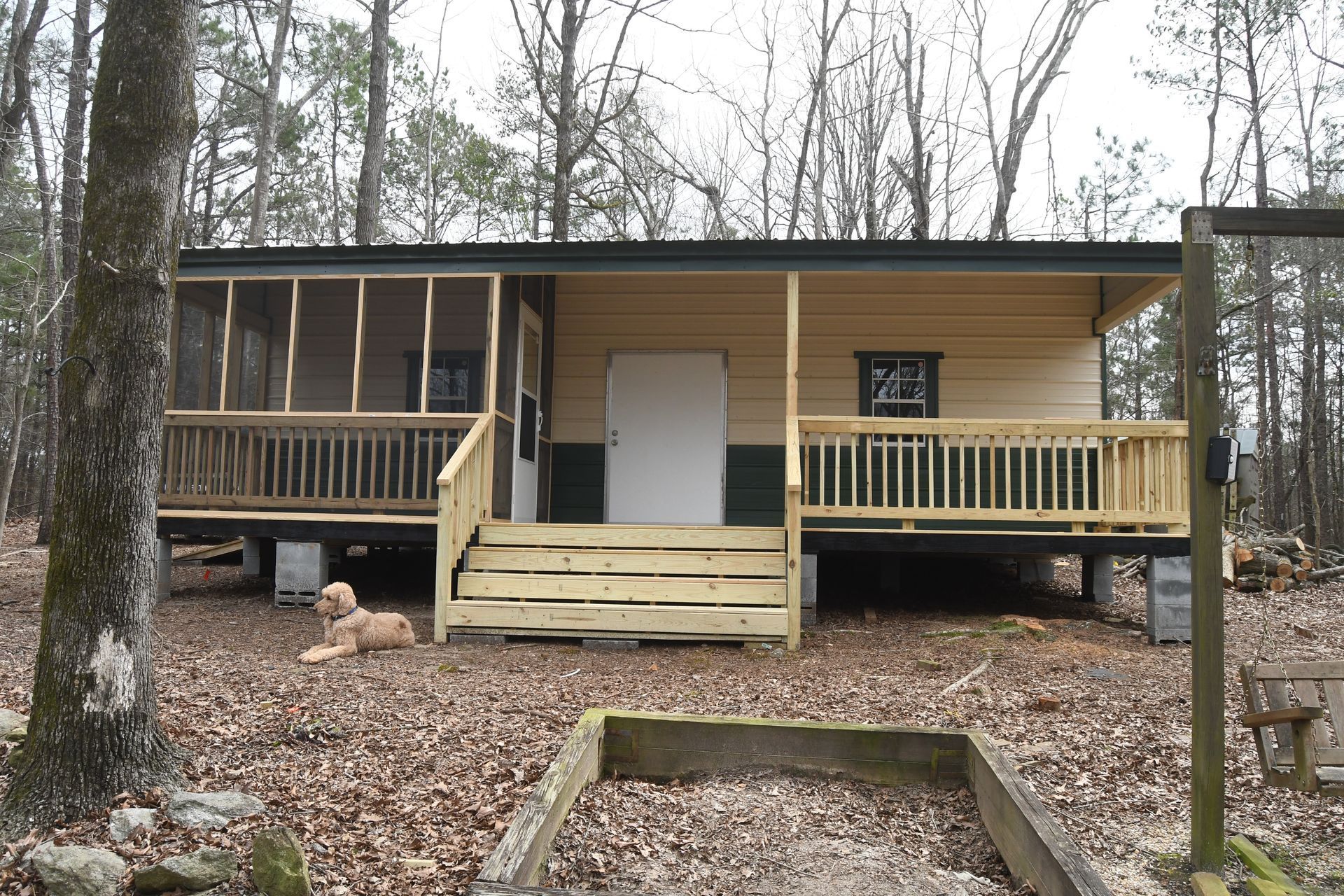 A garage is sitting on top of a gravel hill.