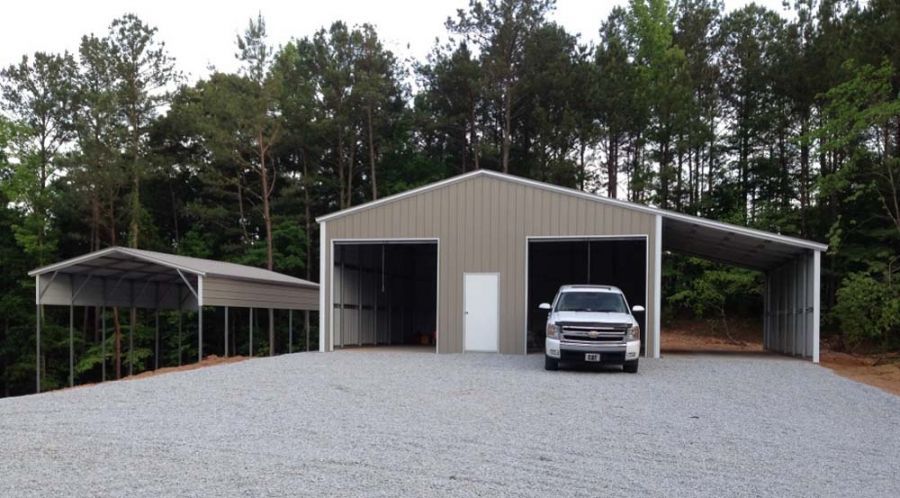 A white truck is parked in front of a metal building