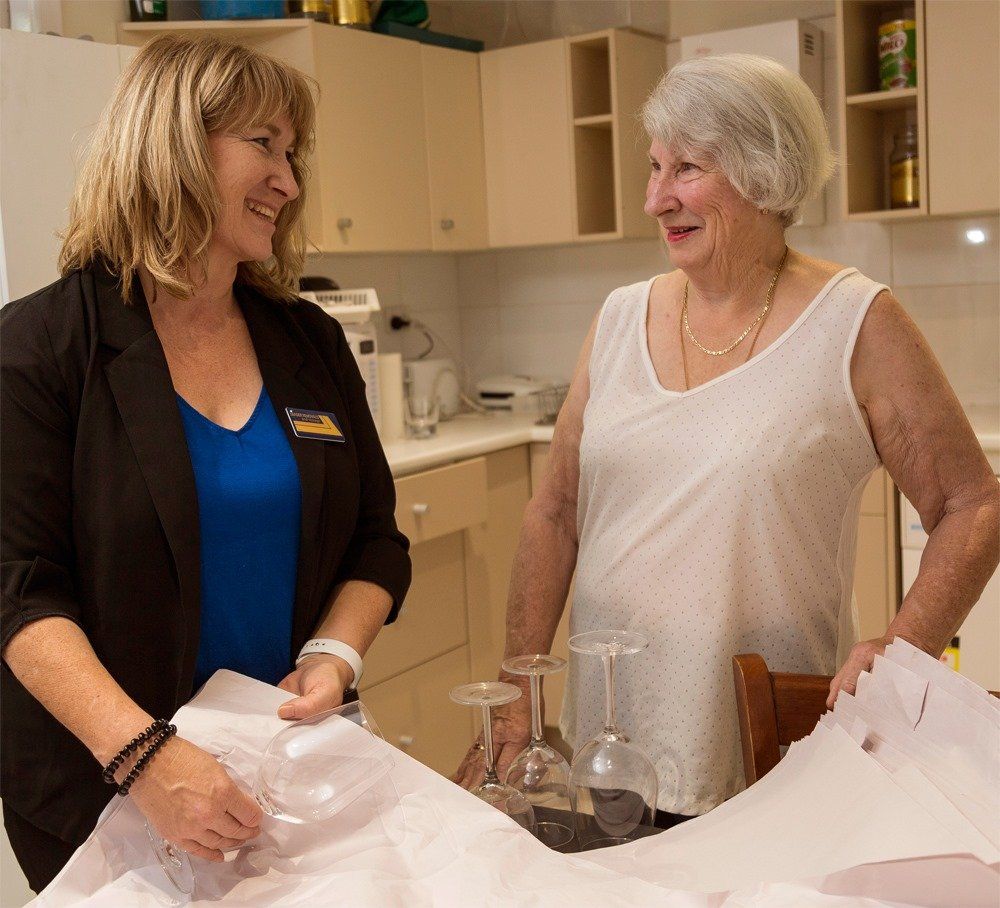 Two Women Are Standing in a Kitchen Talking to Each Other — Leader Removals & Storage in Mitchell, ACT