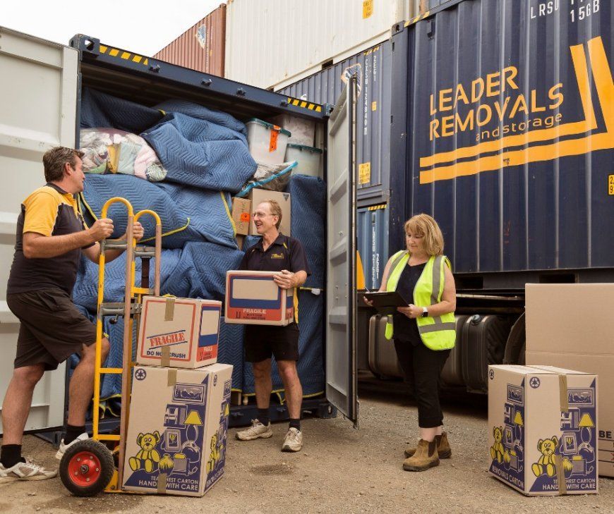 A Group of People Are Loading Boxes Into a Leader Removals Truck — Leader Removals & Storage in Canberra, ACT