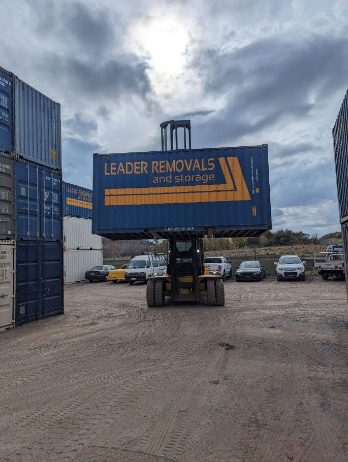 A Large Blue Container is Being Lifted by a Forklift — Leader Removals & Storage in Brisbane, QLD