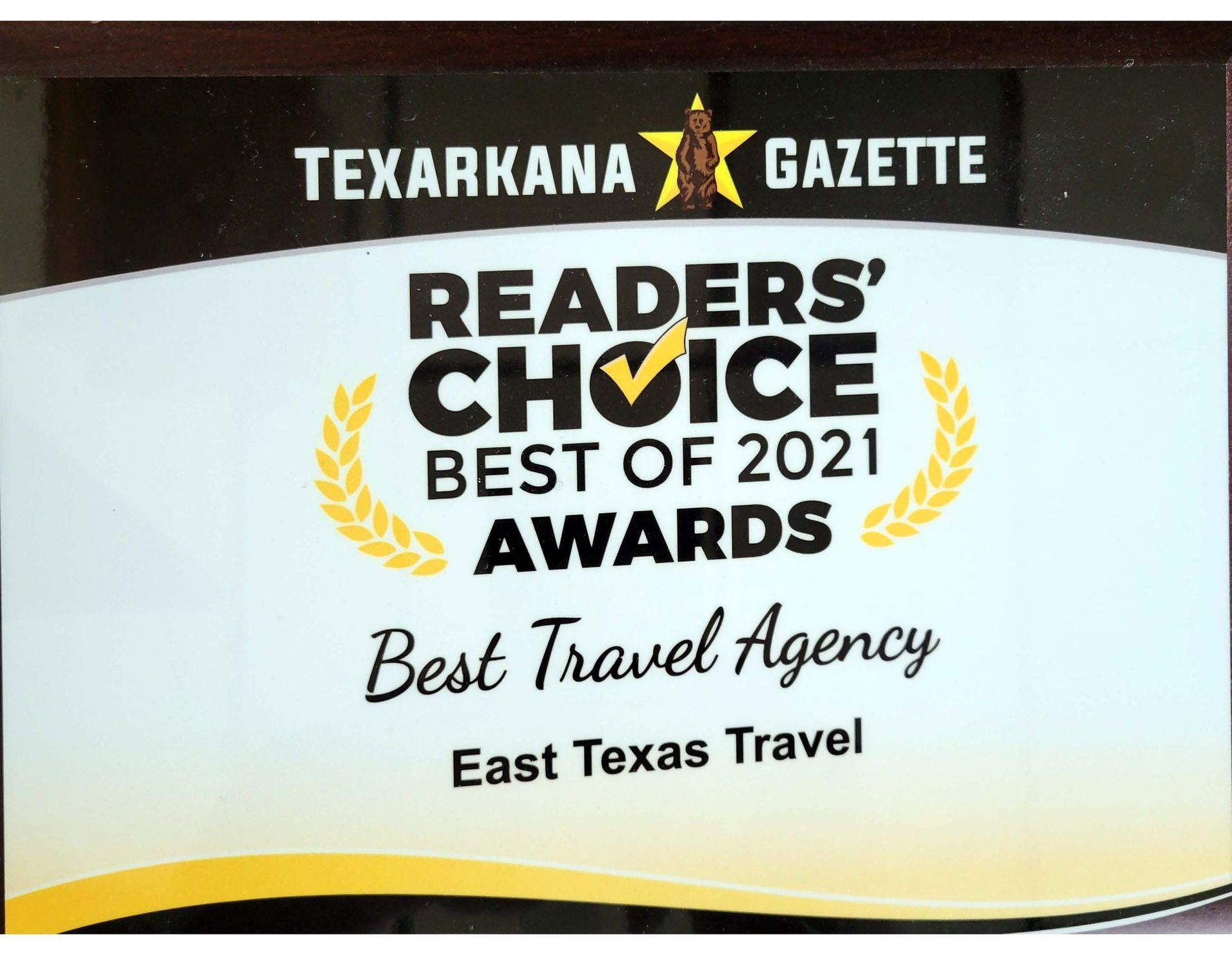 a plaque that says readers choice best of 2021 awards best travel agency in texarkana 