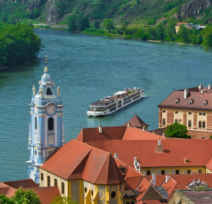 river boat with large iconic red roof buildings in forefront
