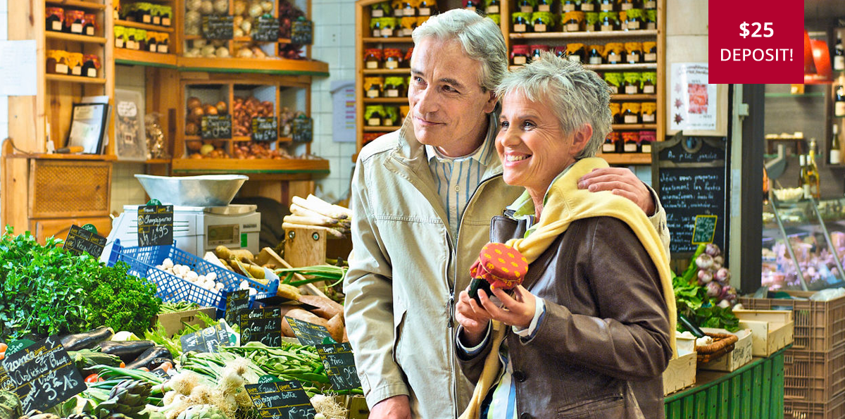 A man and woman are standing in a grocery store looking at vegetables.