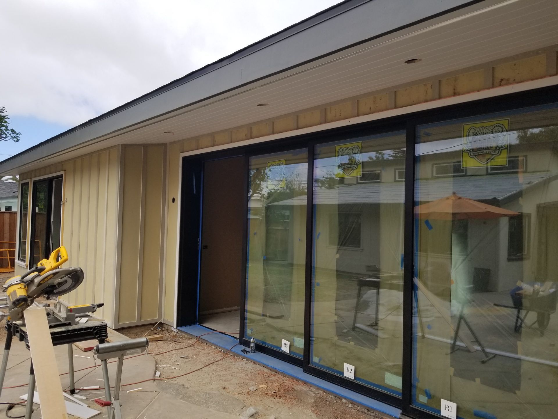 Exterior of a house undergoing construction with a large sliding glass door.