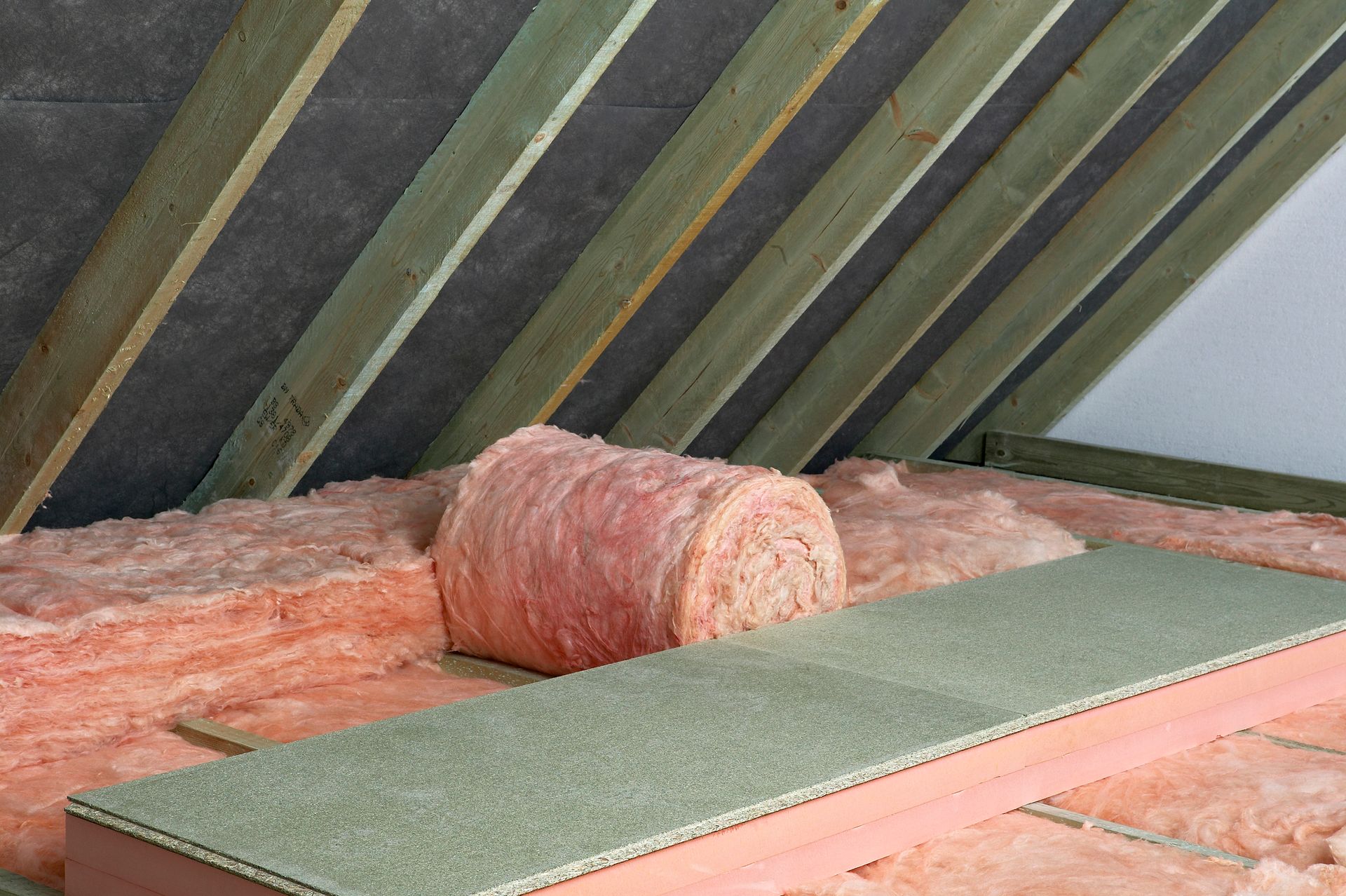 There is a roll of insulation on the floor of the attic.