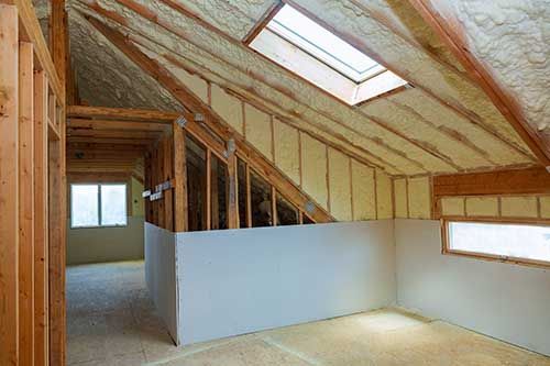 A room in a house under construction with a skylight in the ceiling.