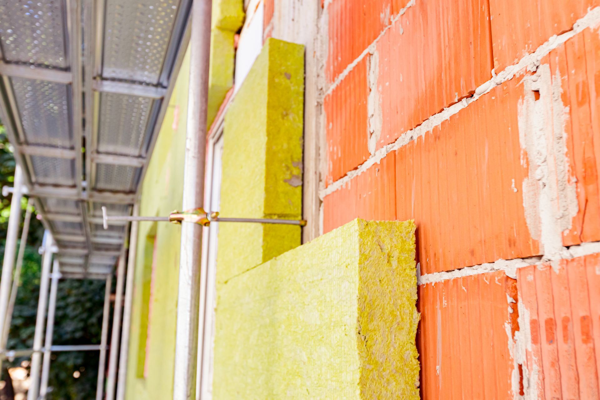 A close up of a brick wall with insulation on it.