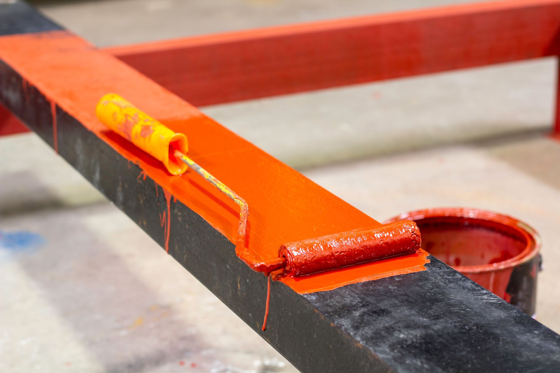 A roller is being used to paint a piece of metal.