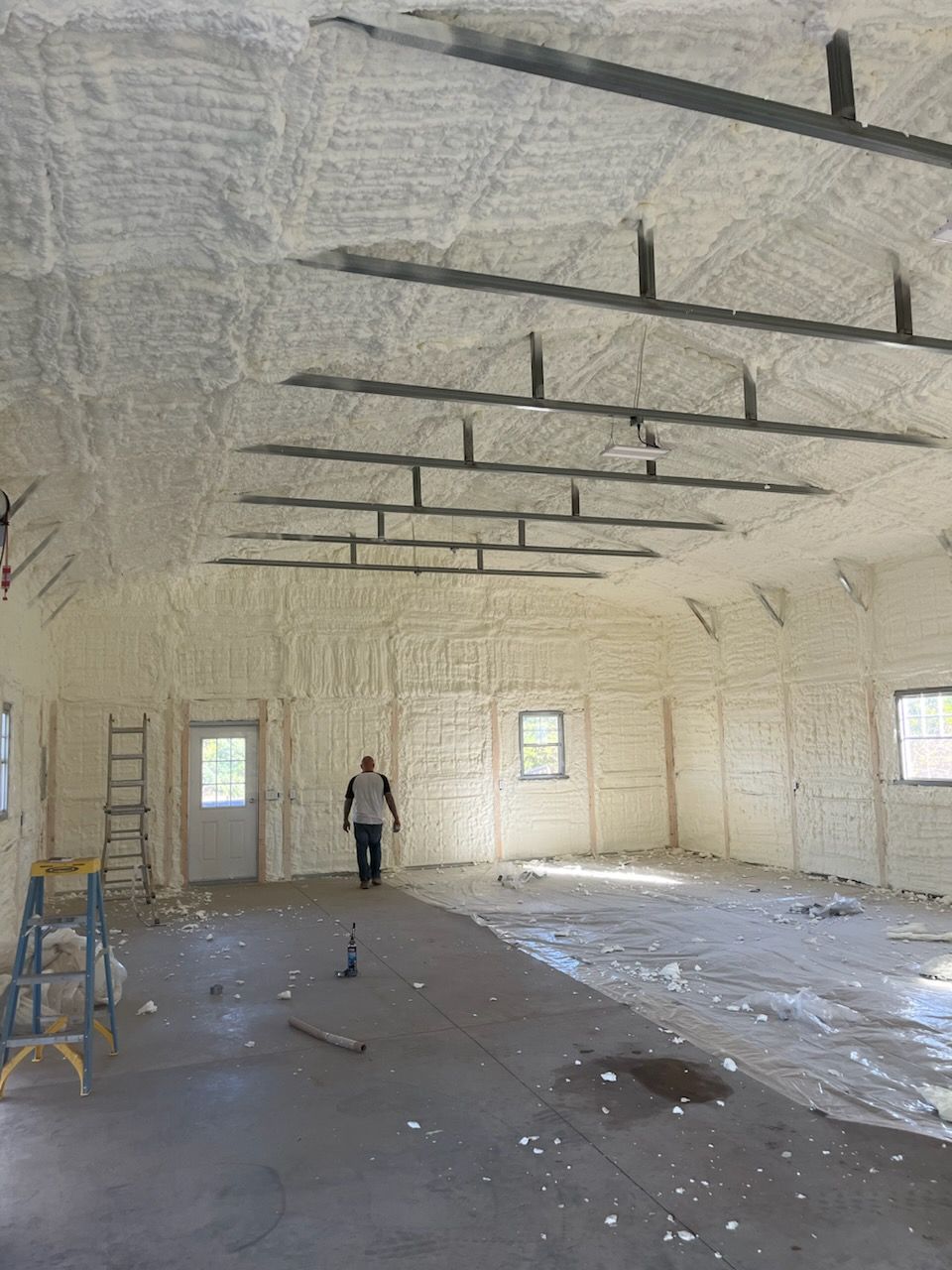 A man is standing in an empty room with a lot of foam on the ceiling.