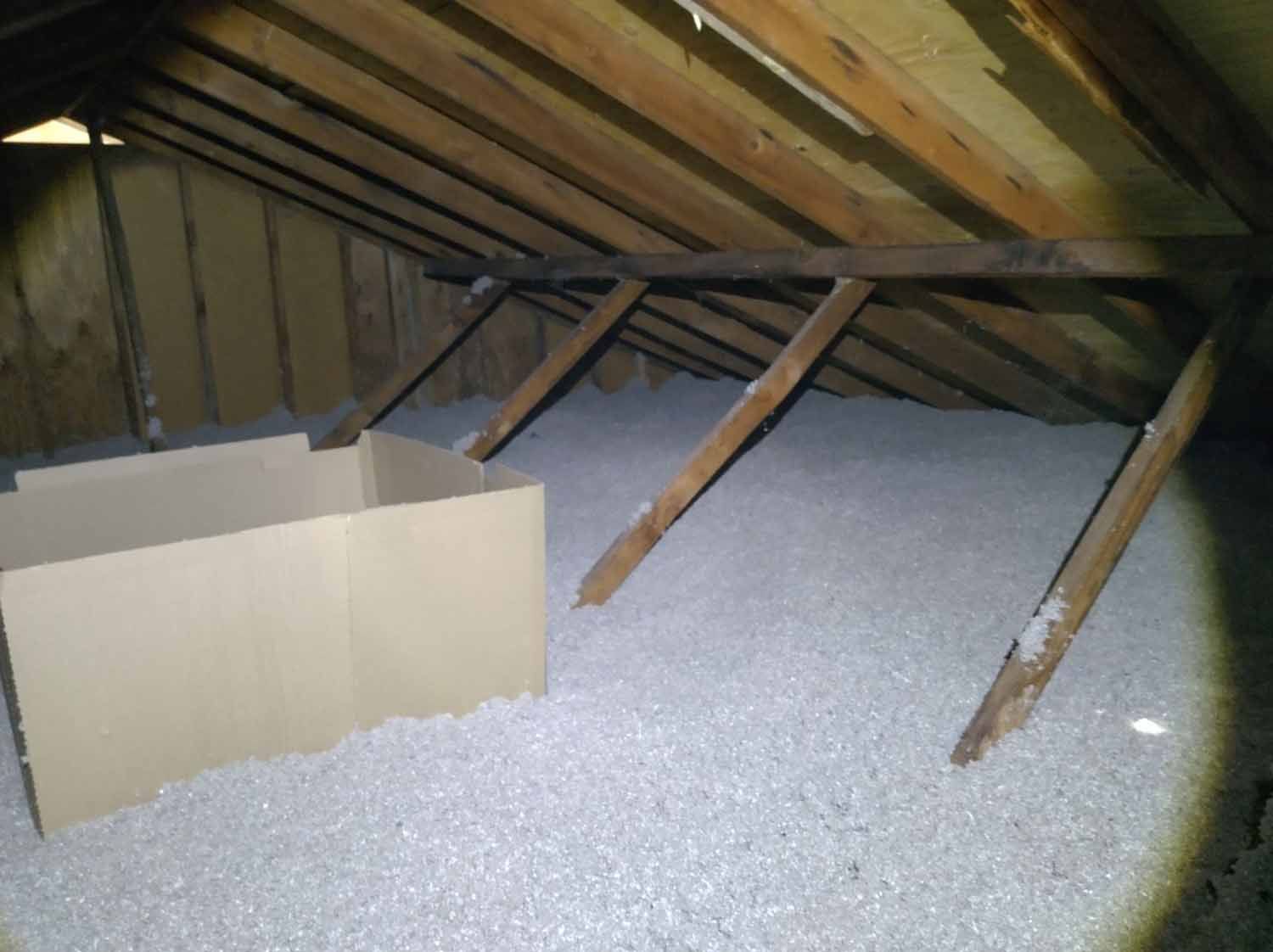 An attic filled with styrofoam and a cardboard box