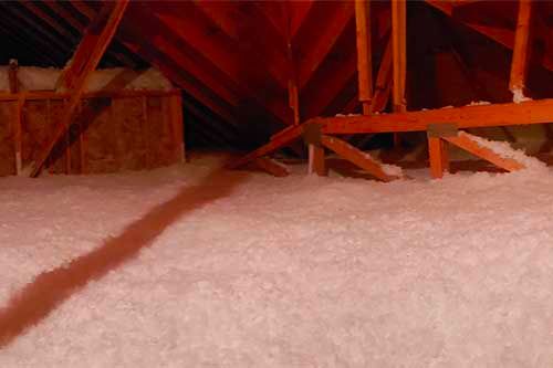 There is a lot of insulation in the attic of a house.