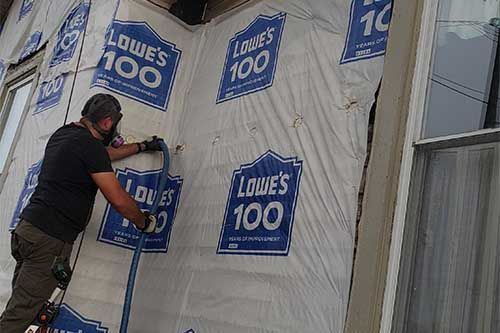 A man is working on the side of a building.