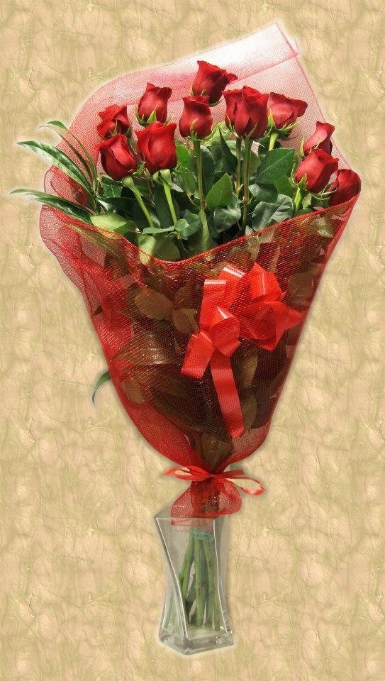 Mazzo di rose rosse avvolto in una rete rossa e legato con un fiocco rosso.
