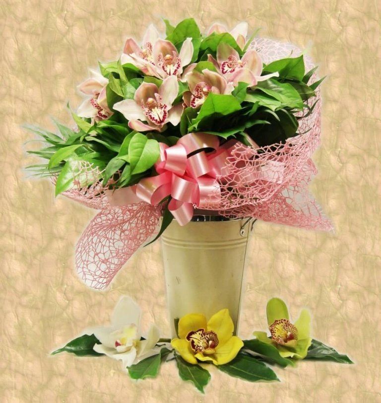 Mazzo di orchidee rosa in un vaso di metallo con un fiocco rosa, tre orchidee sotto.