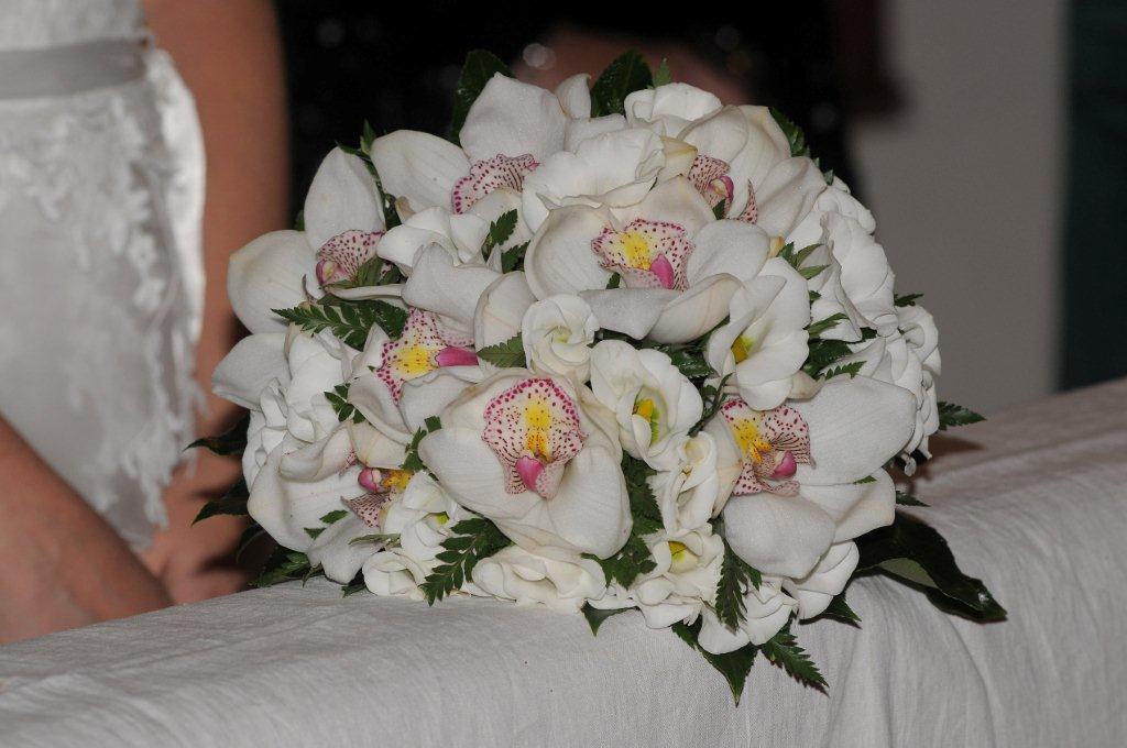Bouquet di orchidee bianche e rosa su un panno bianco.