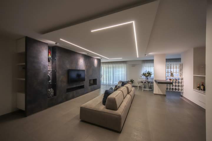 Un soggiorno con un divano e una televisione sulla parete.