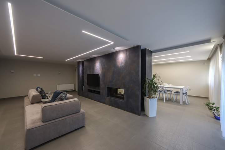 Un soggiorno con divano, televisione, camino e tavolo da pranzo.