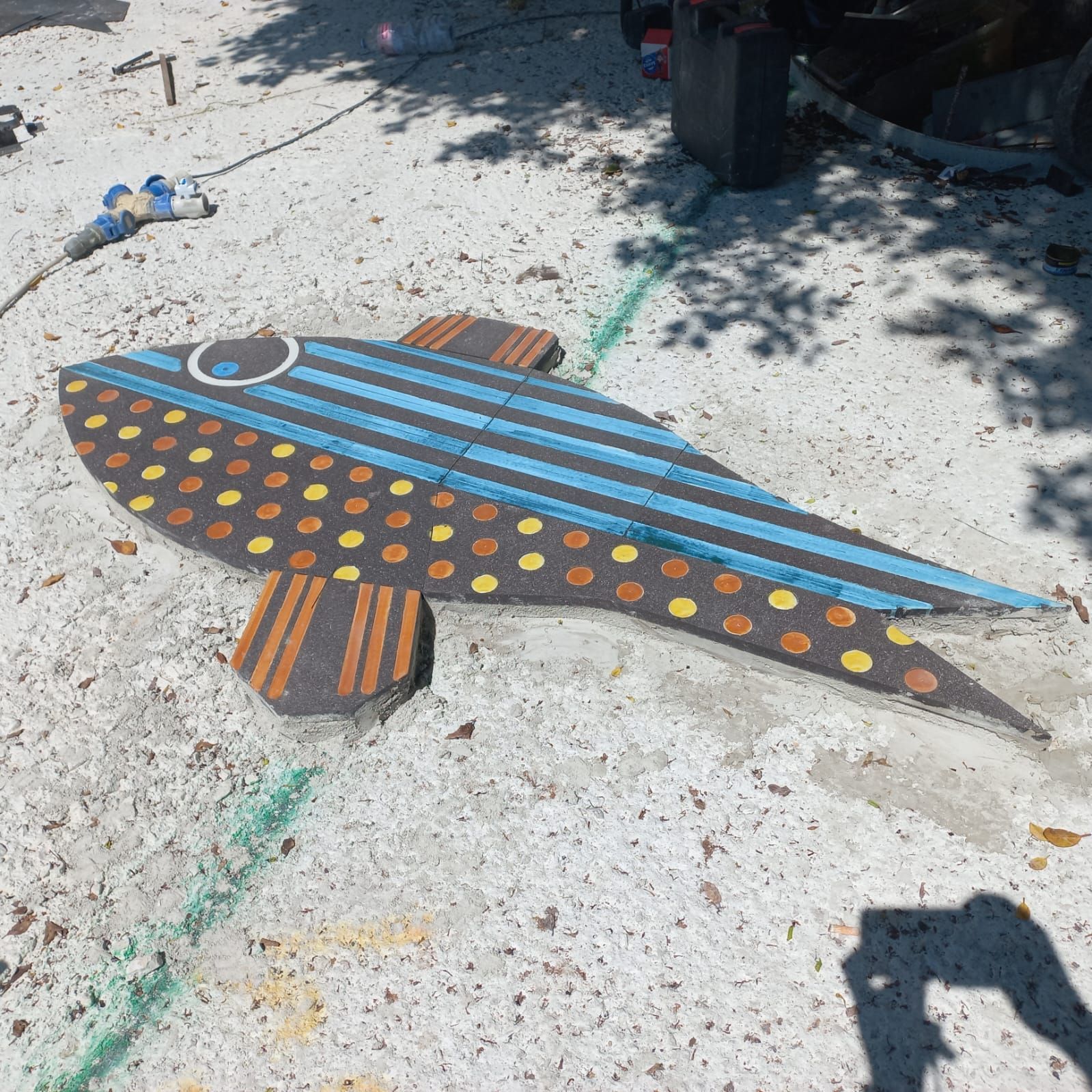 Un pesce colorato è dipinto sul terreno nella sabbia