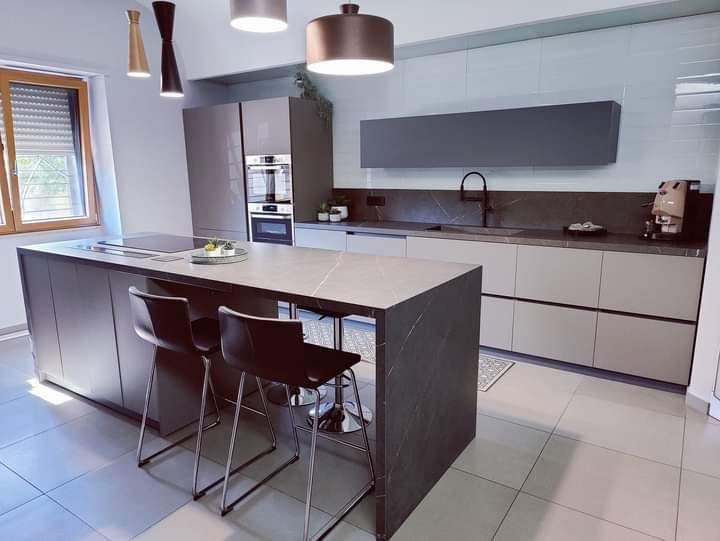 Una cucina con una grande isola e sgabelli