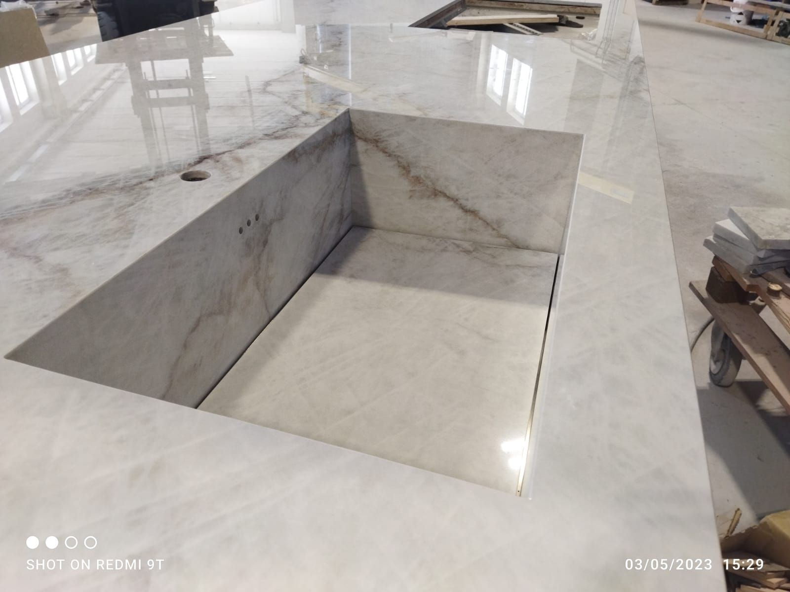 Un grande lavandino è appoggiato su un ripiano in marmo.