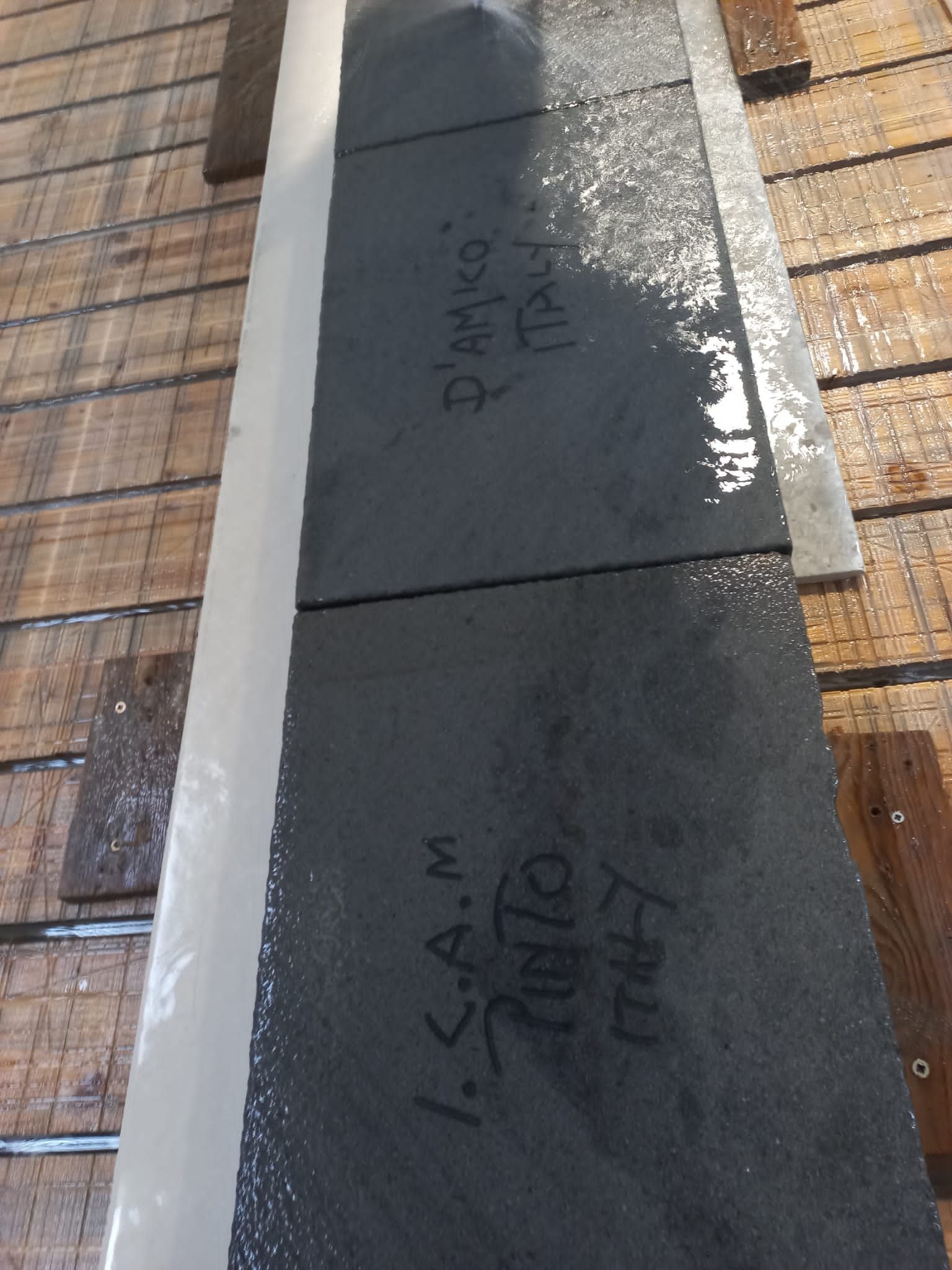 Una fila di piastrelle nere con la scritta isam su di esse