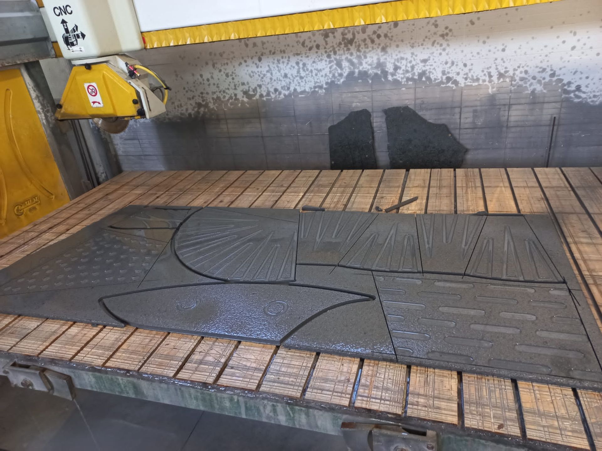 Una macchina sta tagliando un pezzo di metallo su un tavolo di legno.