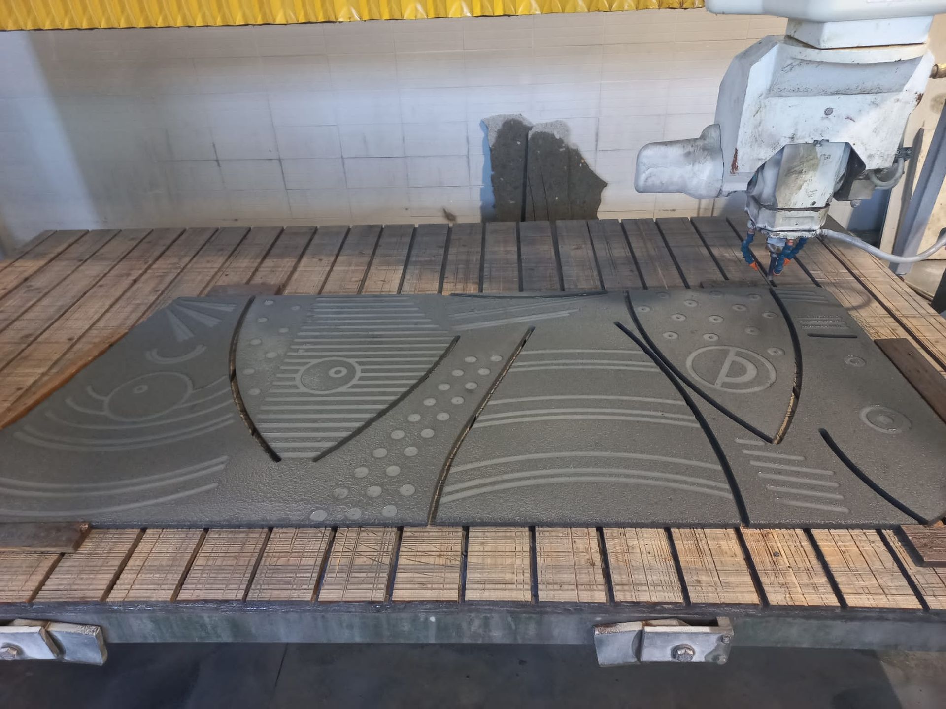 Una macchina sta tagliando un pezzo di cemento su un tavolo di legno.