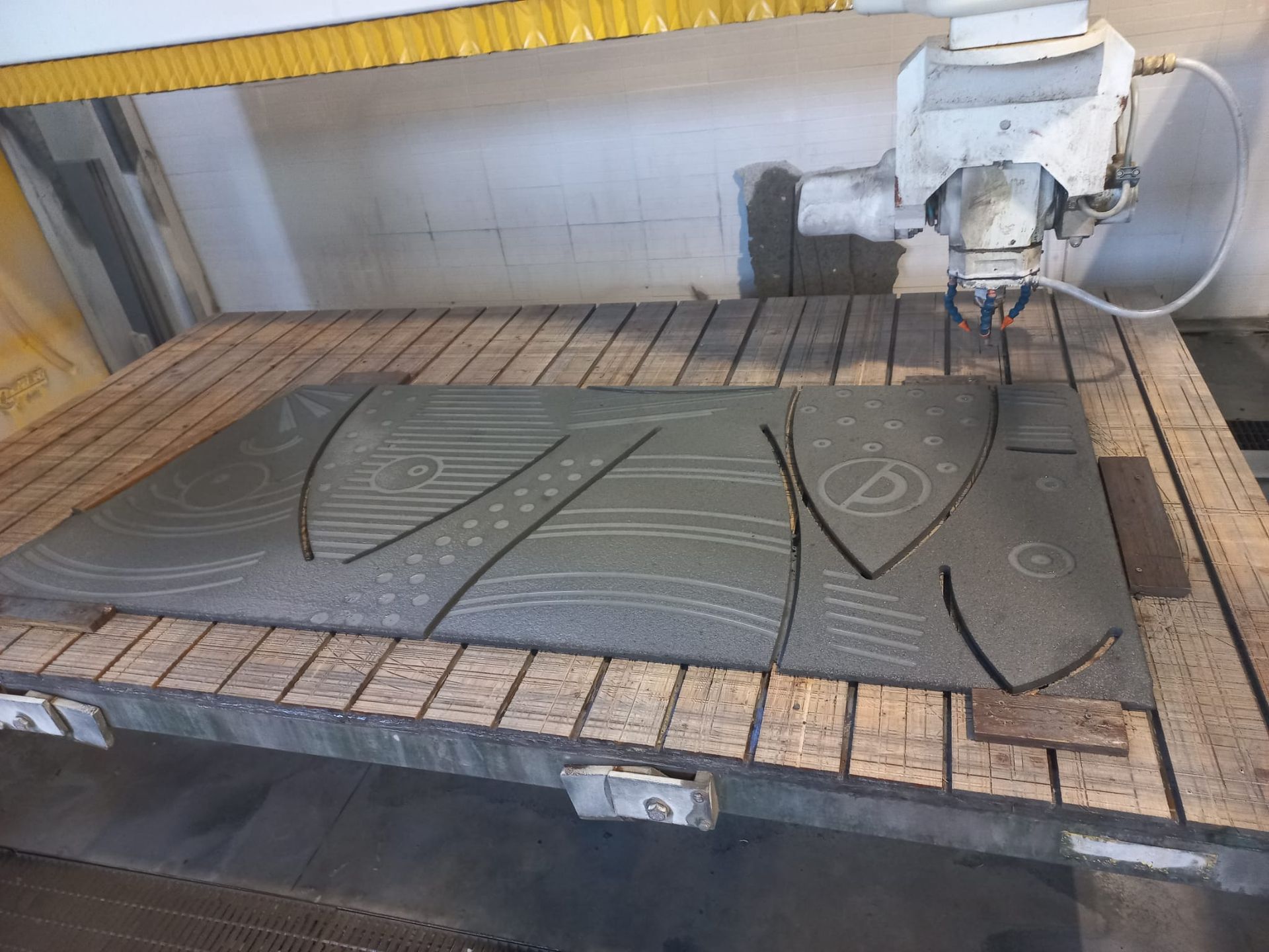 Una macchina sta tagliando un pezzo di legno su un tavolo.