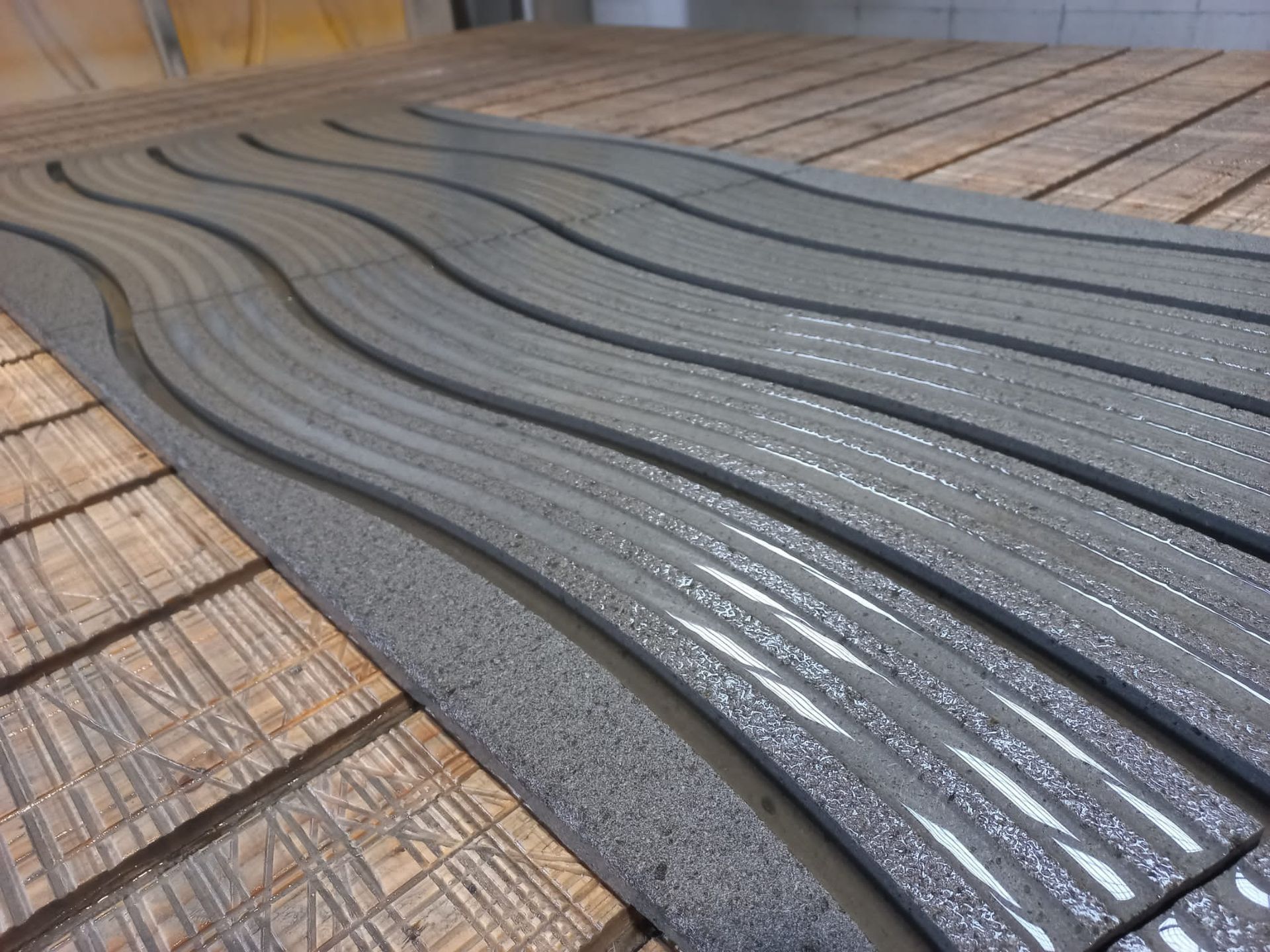 Un tavolo di legno con un tappetino grigio sopra