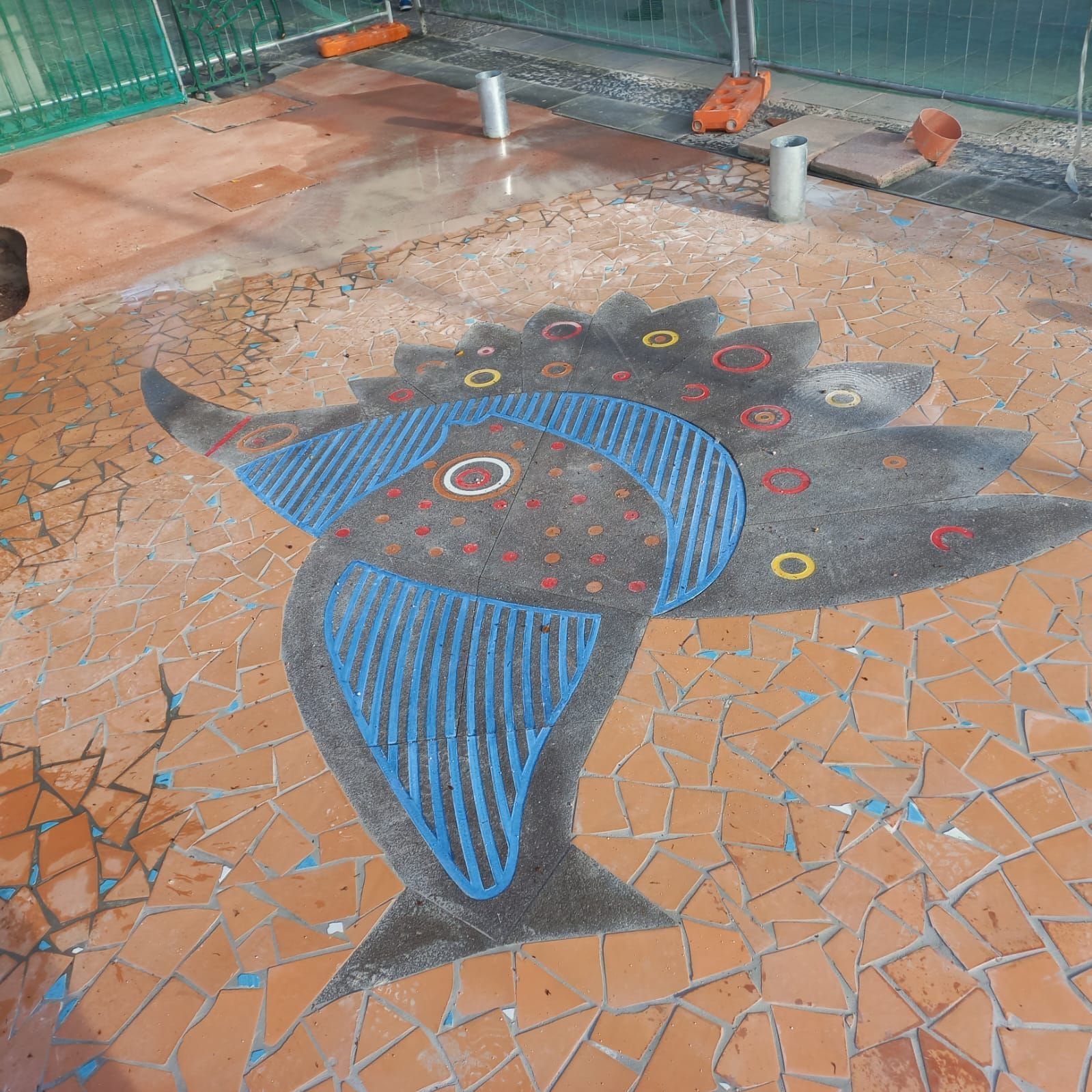 Un disegno di un pesce su un pavimento piastrellato