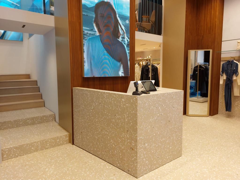 Una donna è in piedi davanti al bancone di un negozio.